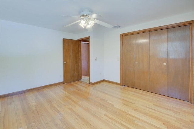 unfurnished bedroom with a closet, baseboards, a ceiling fan, and light wood-style floors