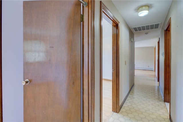 hallway featuring baseboards, baseboard heating, and visible vents