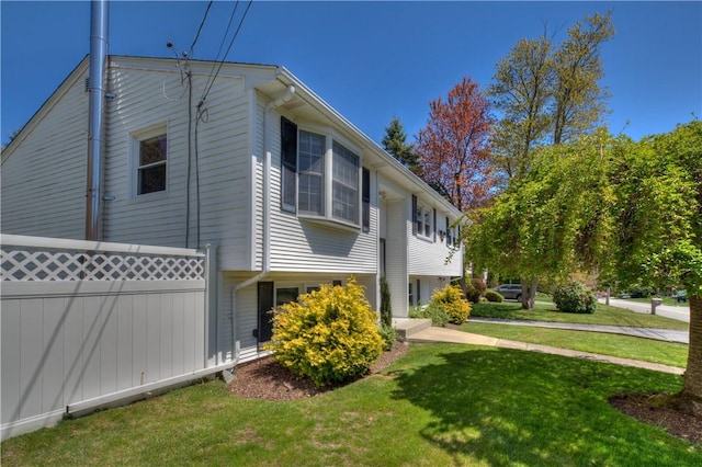view of side of property with a yard and fence