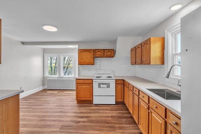 32 Summer St, Woonsocket, RI 02895 - kitchen with radiator heating unit, decorative backsplash, white electric stove, and a sink