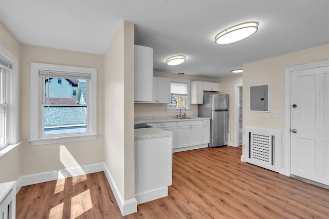 32 Summer St, Woonsocket, RI 02895 - kitchen with light wood-style floors, freestanding refrigerator, a sink, and light countertops