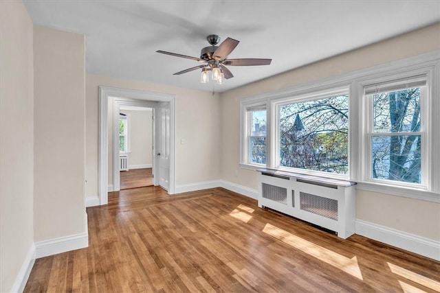 32 Summer St, Woonsocket, RI 02895 - spare room featuring radiator, baseboards, light wood finished floors, and ceiling fan