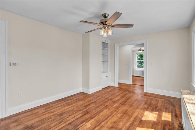 32 Summer St, Woonsocket, RI 02895 - spare room featuring built in features, light wood-style flooring, radiator, a ceiling fan, and baseboards