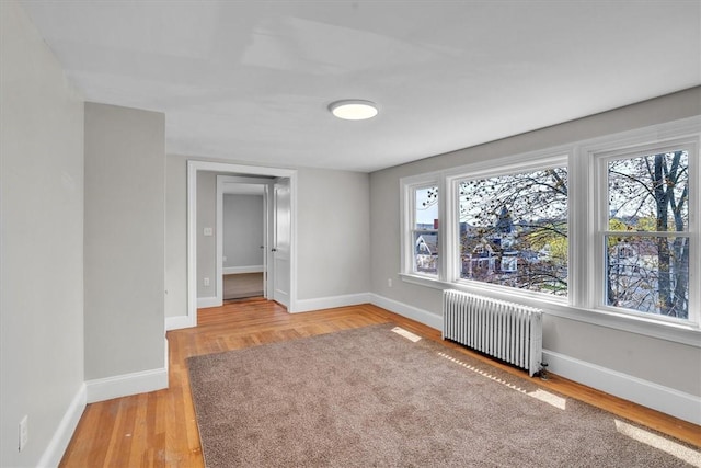 32 Summer St, Woonsocket, RI 02895 - unfurnished room featuring baseboards, light wood-style flooring, radiator, and a wealth of natural light