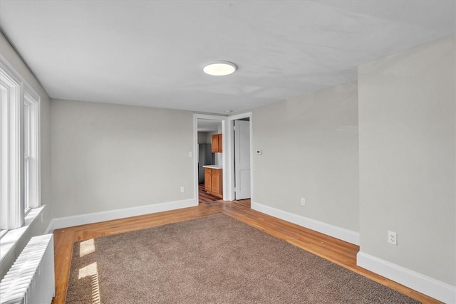 32 Summer St, Woonsocket, RI 02895 - empty room featuring baseboards, radiator, and wood finished floors