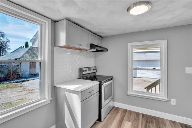 32 Summer St, Woonsocket, RI 02895 - kitchen featuring under cabinet range hood, stainless steel range with electric cooktop, a healthy amount of sunlight, and gray cabinets