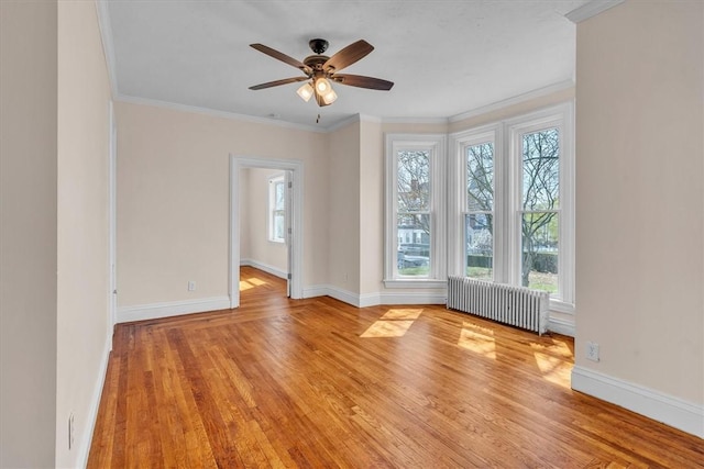 32 Summer St, Woonsocket, RI 02895 - empty room with ceiling fan, radiator heating unit, baseboards, wood finished floors, and ornamental molding