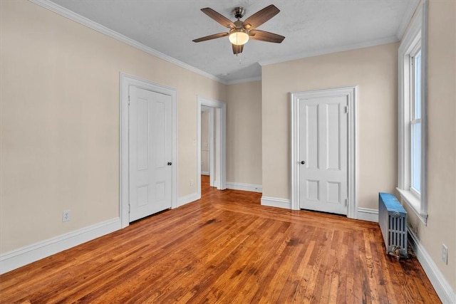 32 Summer St, Woonsocket, RI 02895 - unfurnished bedroom featuring ceiling fan, wood finished floors, baseboards, radiator heating unit, and ornamental molding