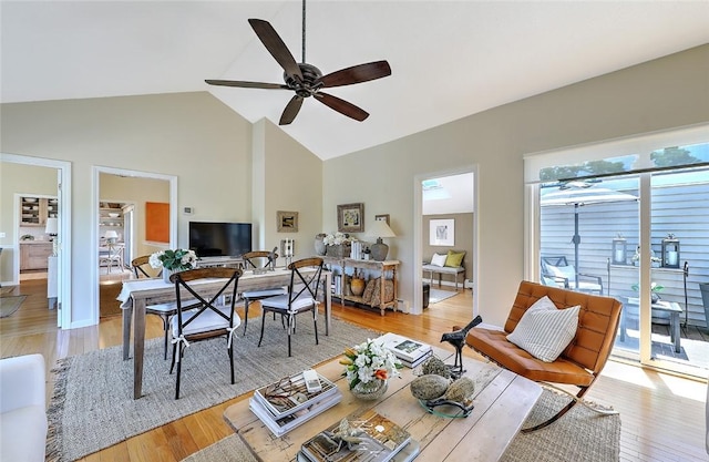 living area with light wood-type flooring, ceiling fan, and high vaulted ceiling