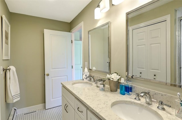 bathroom featuring double vanity, tile patterned floors, a sink, and a baseboard radiator