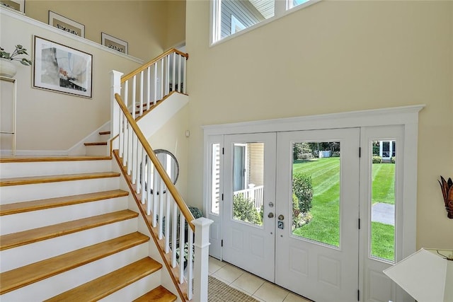 foyer entrance featuring a healthy amount of sunlight, a high ceiling, and stairs