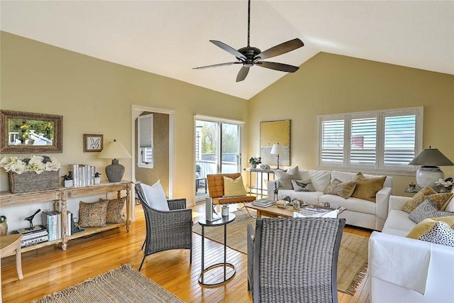 living room with vaulted ceiling, a ceiling fan, and light wood finished floors