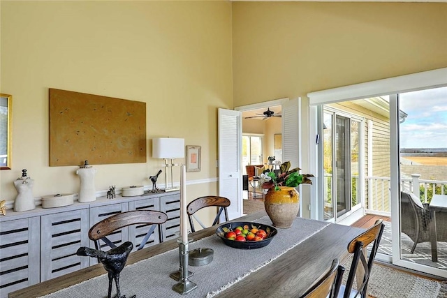 dining space with ceiling fan and a high ceiling