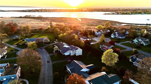 aerial view at dusk with a residential view and a water view