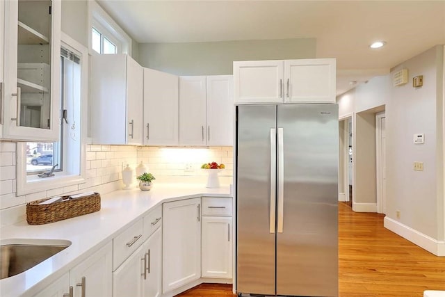 kitchen featuring light countertops, white cabinets, and freestanding refrigerator