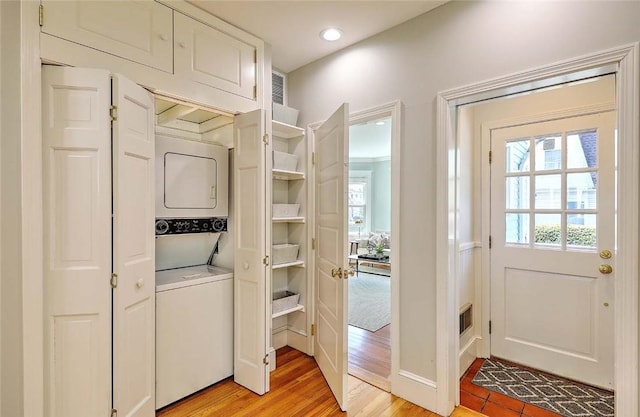 washroom with recessed lighting, laundry area, stacked washing maching and dryer, and light wood-type flooring