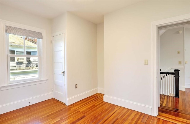 empty room featuring baseboards and light wood finished floors