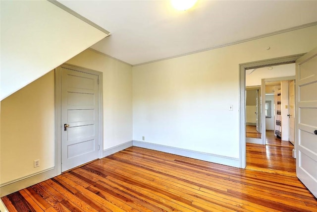 bonus room with baseboards and light wood-style flooring