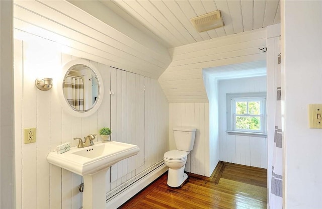 bathroom featuring toilet, wood walls, wooden ceiling, a baseboard radiator, and hardwood / wood-style flooring