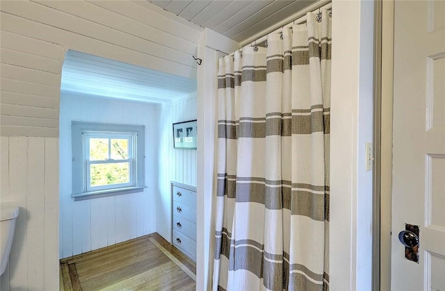 full bath with wooden ceiling, a shower with curtain, wood walls, and wood finished floors