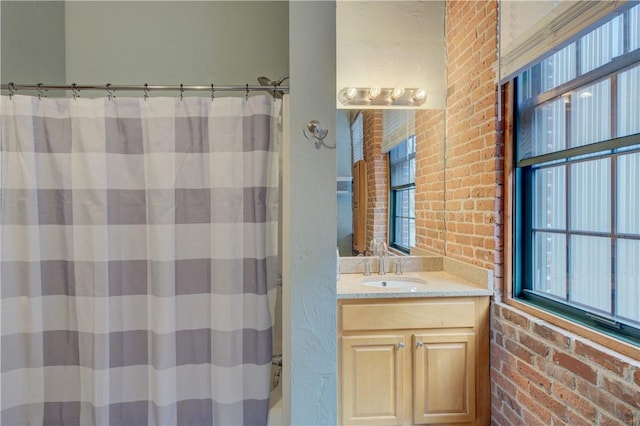 bathroom with vanity, plenty of natural light, brick wall, and a shower with curtain