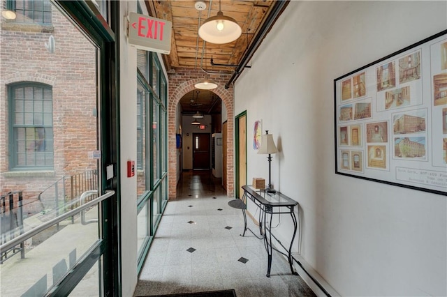 hallway featuring brick wall