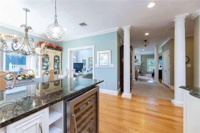 16 Central St, Charlestown, RI 02813 - kitchen featuring crown molding, light wood finished floors, recessed lighting, wine cooler, and ornate columns