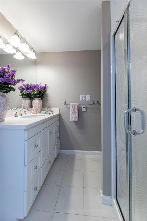 16 Central St, Charlestown, RI 02813 - full bathroom with double vanity, a sink, baseboards, and a shower stall