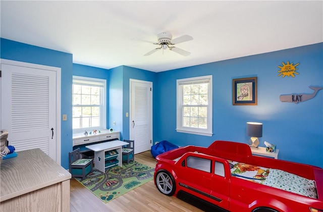 bedroom featuring multiple windows, a ceiling fan, and wood finished floors