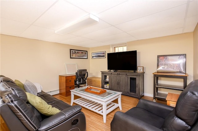 living room with baseboards, a drop ceiling, wood finished floors, and a baseboard radiator