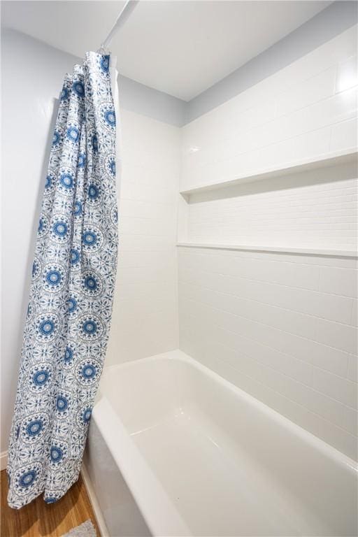 bathroom with shower / bath combination with curtain and wood finished floors