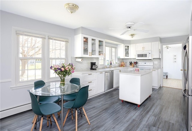 kitchen with a sink, light countertops, a center island, stainless steel appliances, and backsplash