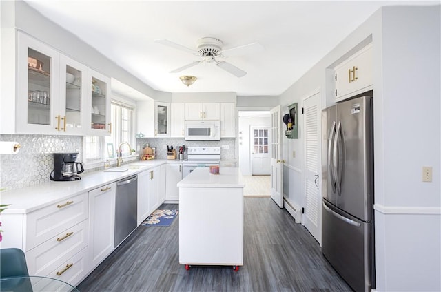 kitchen featuring decorative backsplash, light countertops, white cabinets, a sink, and stainless steel appliances