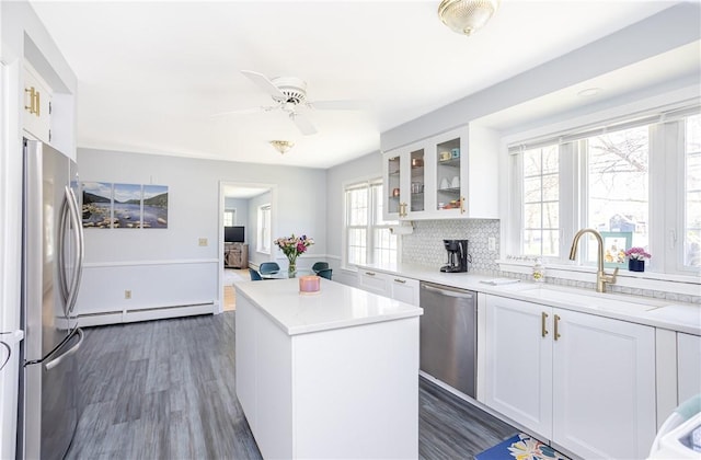 kitchen featuring a sink, glass insert cabinets, white cabinetry, a ceiling fan, and appliances with stainless steel finishes