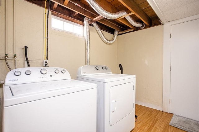 laundry room featuring laundry area, light wood finished floors, and independent washer and dryer