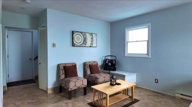 living area featuring baseboards and a baseboard heating unit