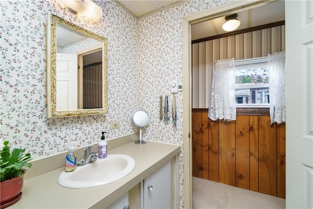 bathroom featuring vanity and wallpapered walls