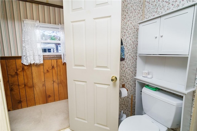 bathroom with toilet and wallpapered walls