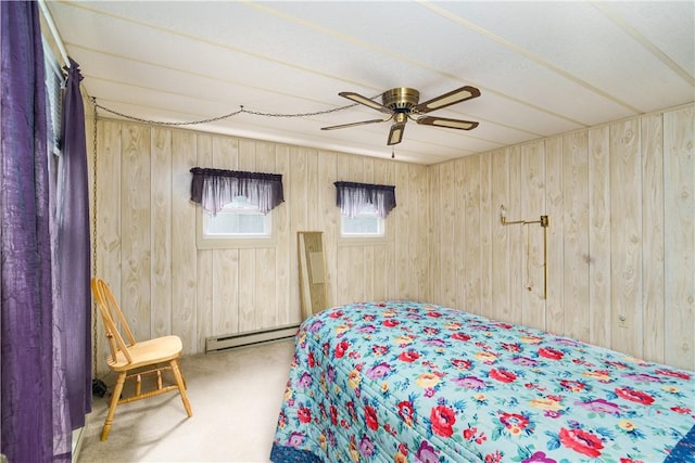 carpeted bedroom featuring a ceiling fan, a baseboard heating unit, and wood walls