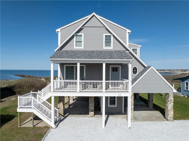 53 Stanton Ave, Narragansett, RI 02882 - view of front facade featuring roof with shingles, a porch, a water view, a carport, and driveway