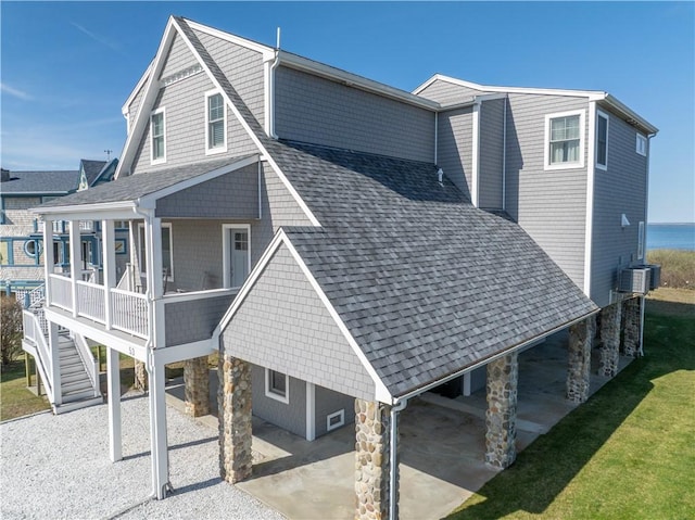 53 Stanton Ave, Narragansett, RI 02882 - back of property with a carport, roof with shingles, stone siding, and cooling unit