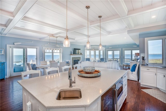 53 Stanton Ave, Narragansett, RI 02882 - kitchen with dark wood finished floors, a sink, white cabinets, coffered ceiling, and an island with sink