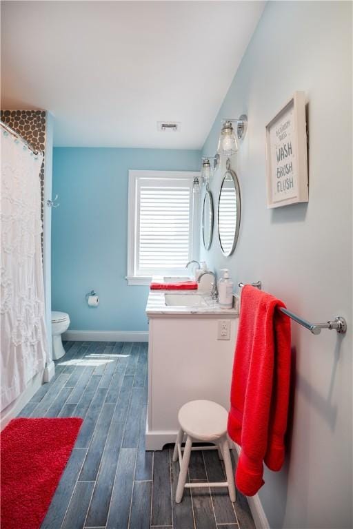 53 Stanton Ave, Narragansett, RI 02882 - full bath featuring vanity, visible vents, wood finished floors, toilet, and baseboards