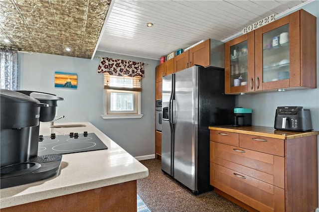 86 Quannacut Rd Unit A, Westerly, RI 02891 - kitchen with appliances with stainless steel finishes, baseboards, brown cabinetry, light countertops, and glass insert cabinets