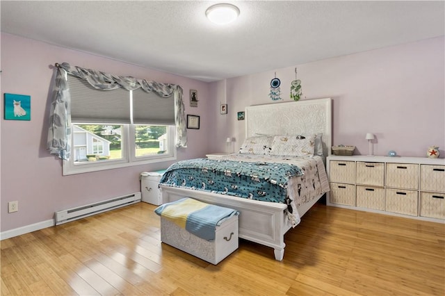 86 Quannacut Rd Unit A, Westerly, RI 02891 - bedroom featuring baseboard heating, light wood-type flooring, and baseboards