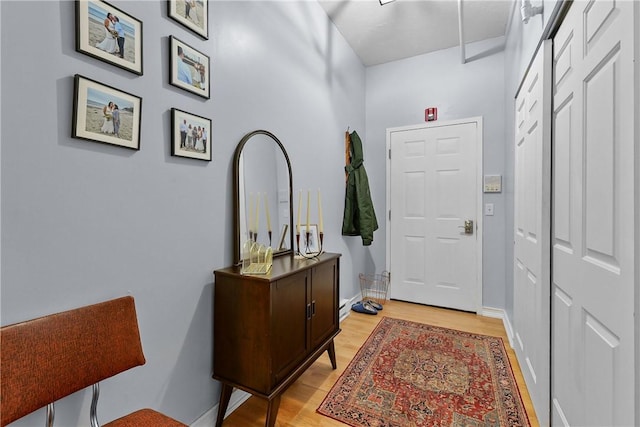 doorway to outside with baseboards and light wood-style floors