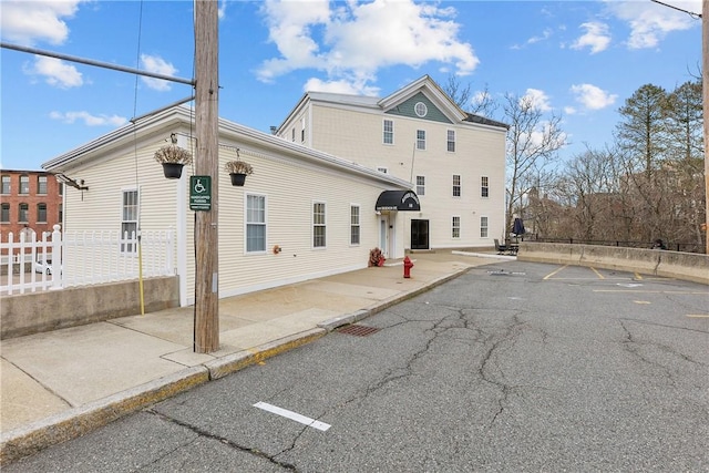 view of front facade with fence and uncovered parking