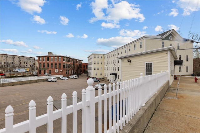 view of property exterior featuring fence and uncovered parking