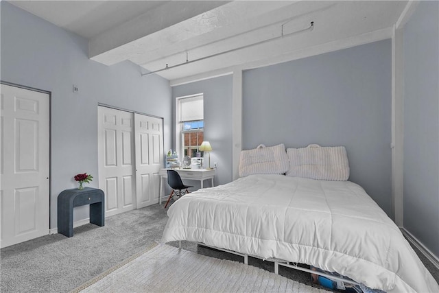 bedroom with carpet floors, baseboards, a closet, and beamed ceiling