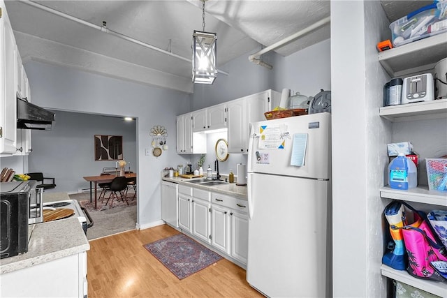 kitchen with white appliances, light countertops, ventilation hood, white cabinets, and light wood finished floors